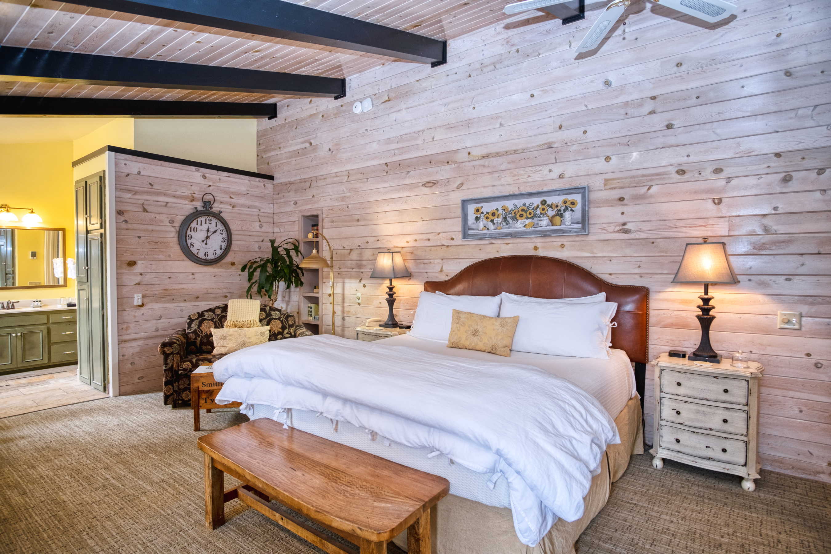 The Sunrise Suite at Country Willows Inn & Estate in Ashland, Oregon has cheerful interior with yellows, golds, and browns surrounding the king bed, fireplace, and roman soaking tub.