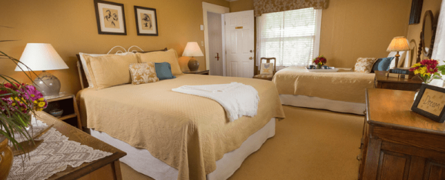 The Cedar Room at Country Willows Inn & Estate in Ashland, Oregon has a king size bed and also a twin bed to accommodate a third guest in the room. Views to the gardens and mountains from the porch just outside the bedroom door are breathtaking.