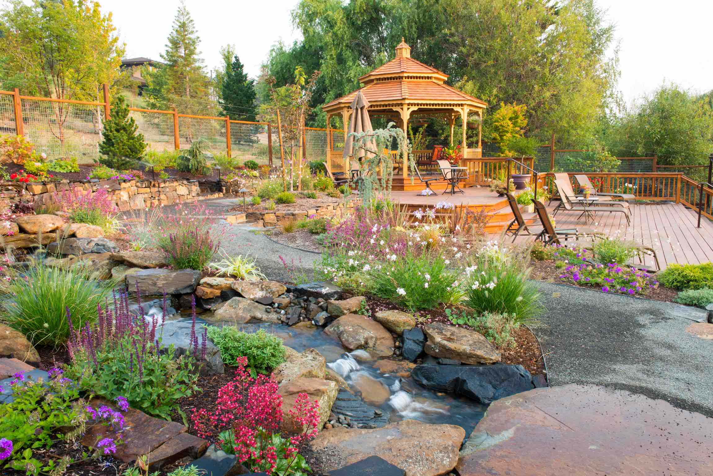 The garden paths at Country Willows Inn & Estate in Ashland, Oregon meander past the koi ponds and brook, and lead to the gazebo and pool deck with umbrellas and reclining chaise loungers.