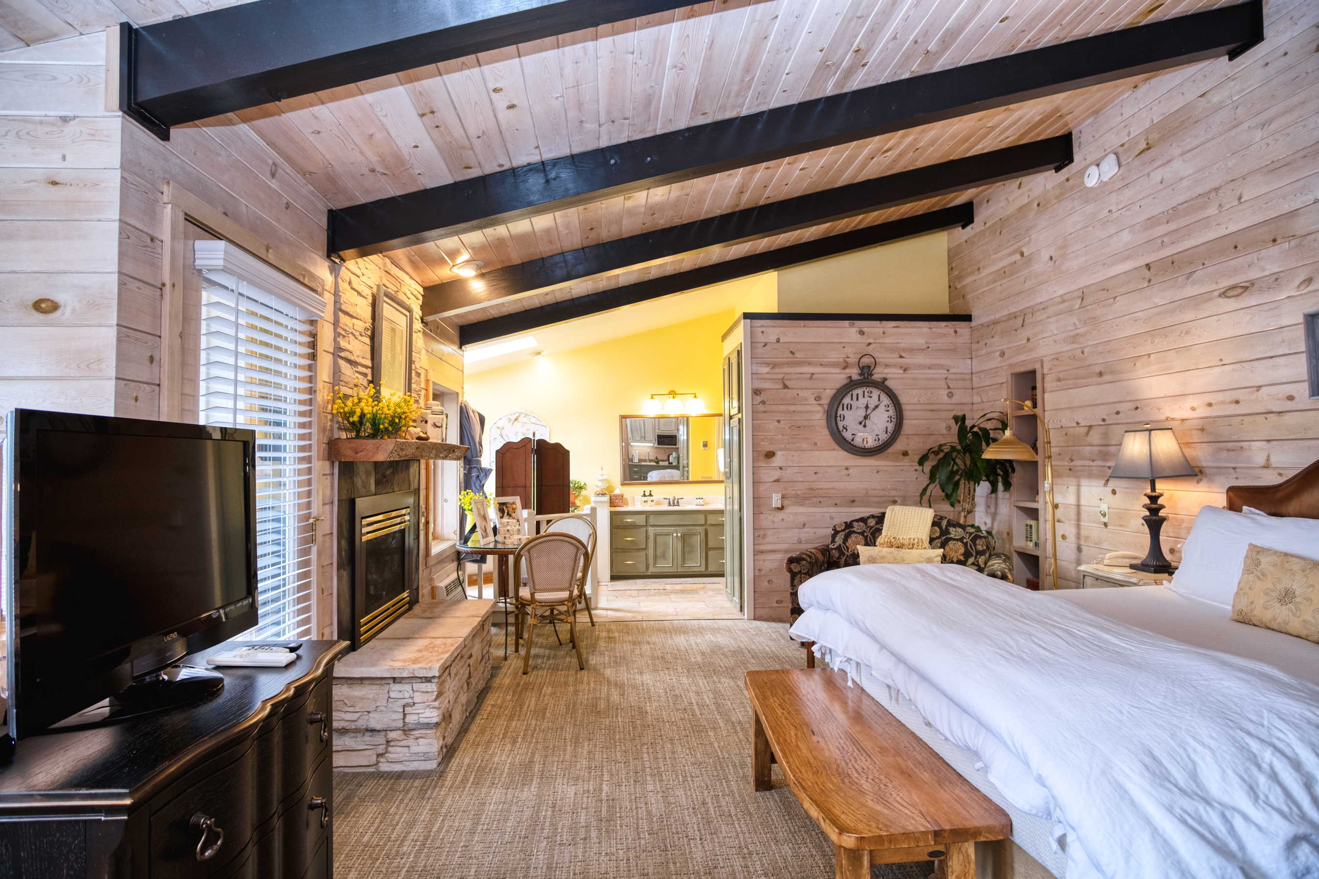 The sunrise Suite at Country Willows Inn & Estate in Ashland, Oregon has a charming, sunny interior with a fireplace, oversize roman soaking tub, heated bathroom floors, and a large private deck overlooking the mountainside.